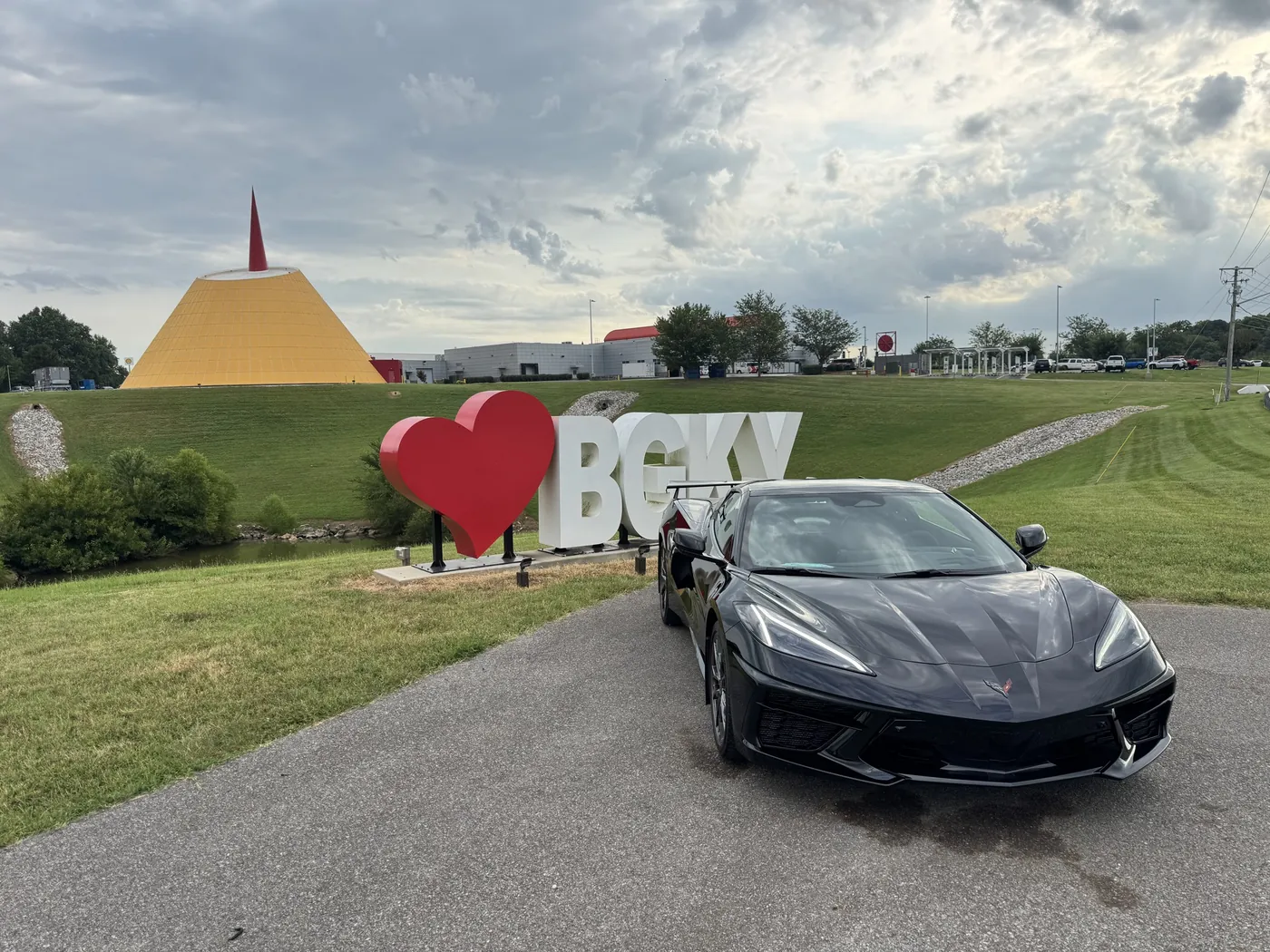 A white Corvette parked in front of the BGKY sign and the museum Skydome