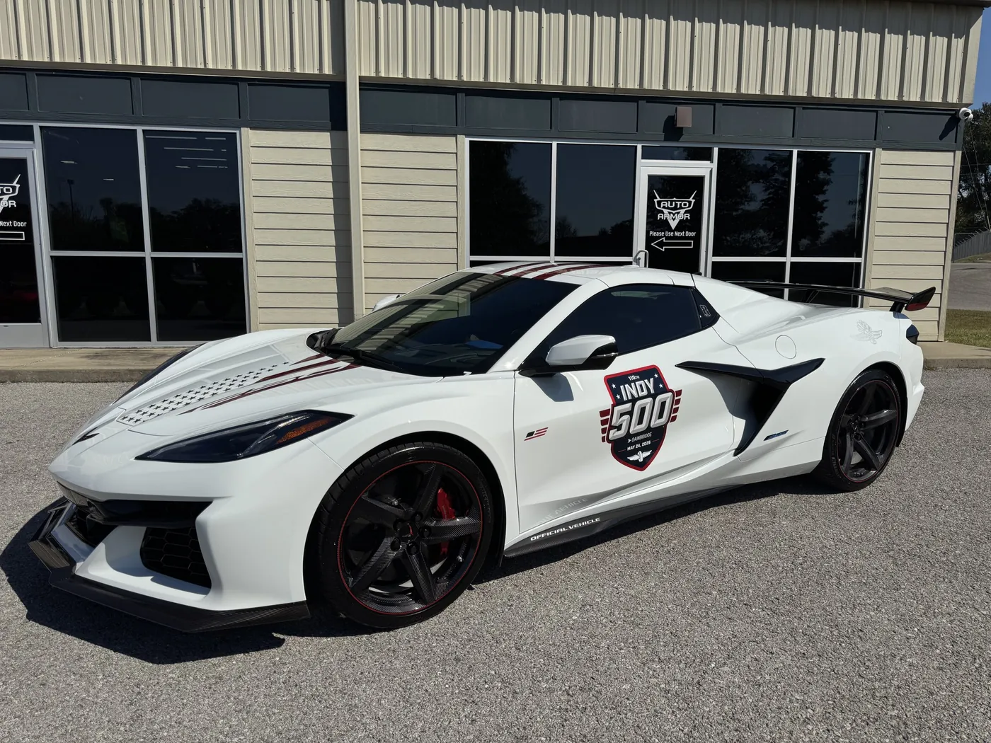 A white Corvette with Indy 500 graphics outside the Auto Armor shop