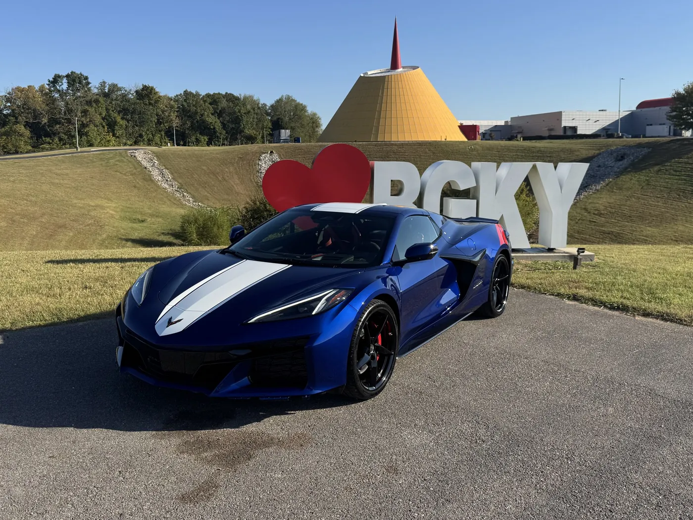 A blue Corvette with a deep gloss in front of the museum Skydome