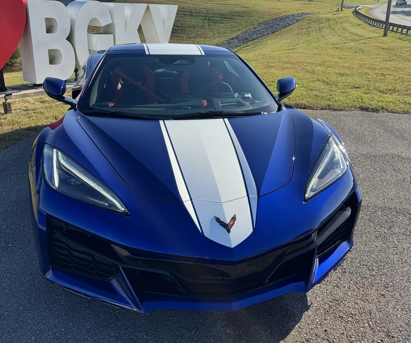 The front of a blue Corvette with both headlights outlined in red